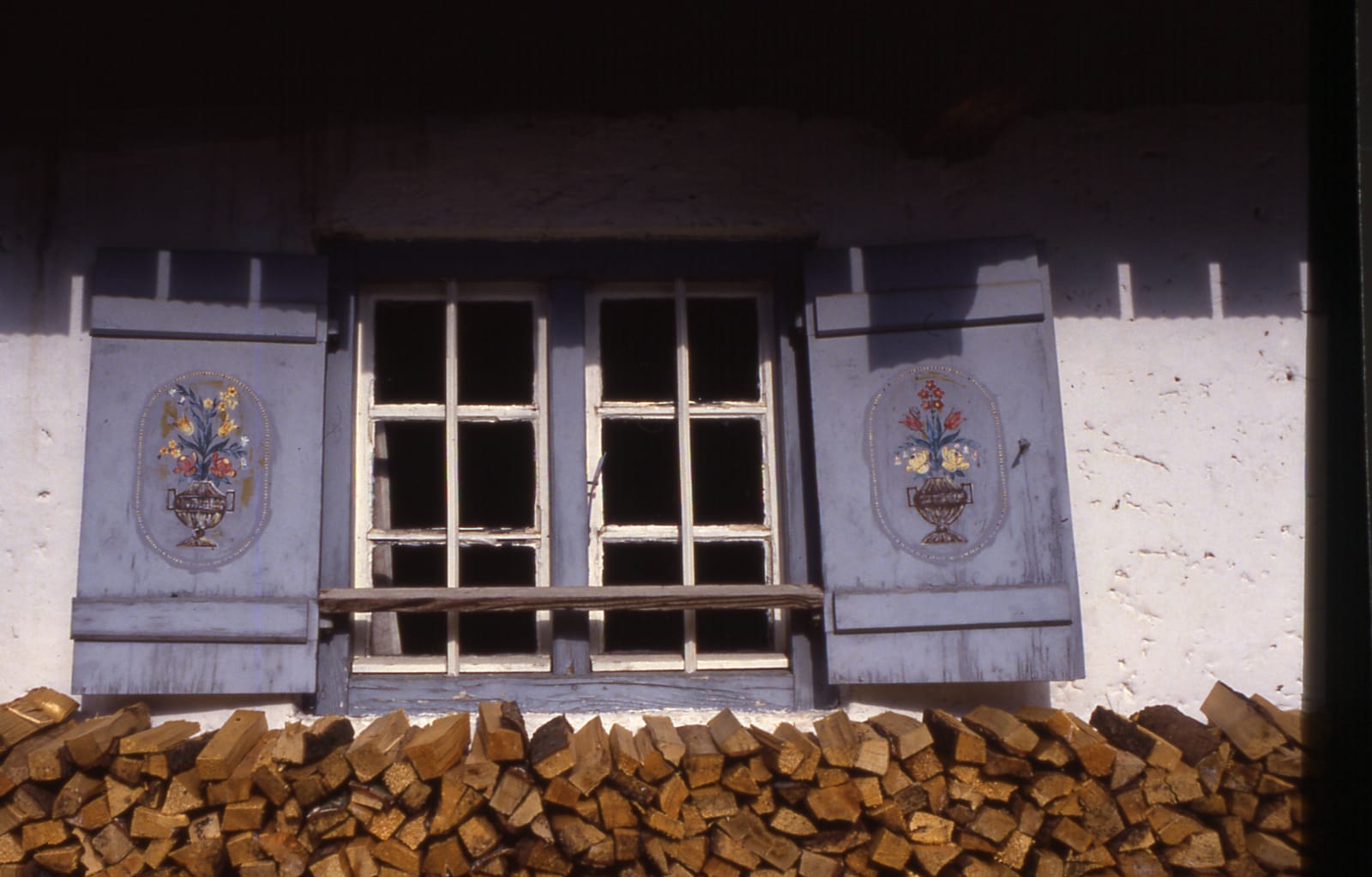 Bemaltes Bauernhausfenster mit Lüftlmalerei und Holzstoß (Dia-Scan)
