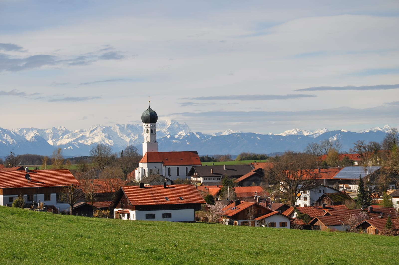 Münsing mit St. Michael vor schneebedeckter Alpenkette