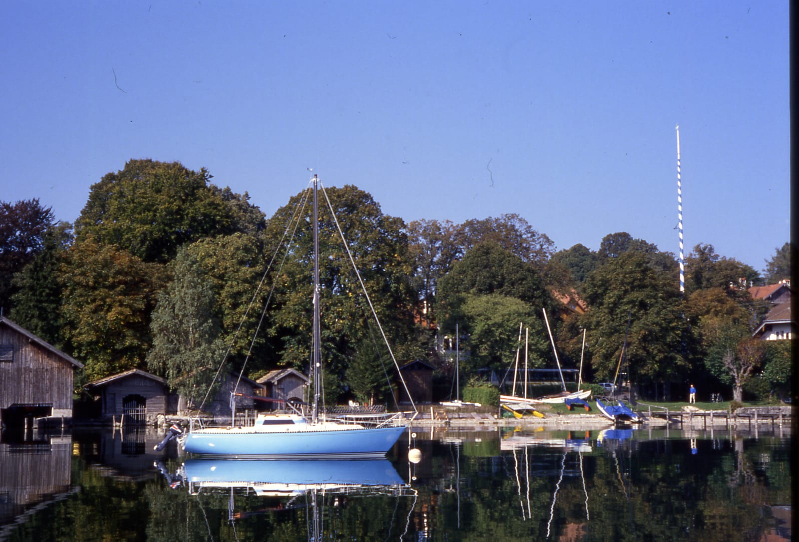 Segelboot im Hafen zwischen den Bootshäusern (Dia-Scan)